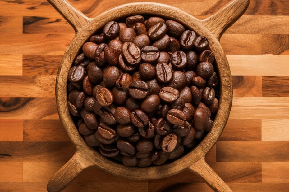 grãos de café torrado em uma vasilha de madeira sobre uma mesa de madeira